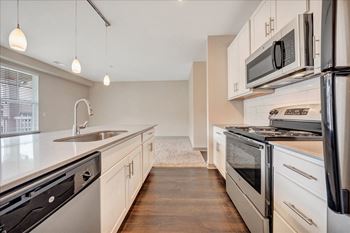 a kitchen with white cabinets and stainless steel appliances  at Avellan Springs Apartments, North Carolina